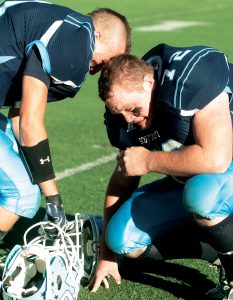 Scott City senior Lane Hayes (72) and teammate sophomore Kyle Cure, get emotional after the Beavers 21-14 loss to Rossville in the 2014 class 3A state title game.