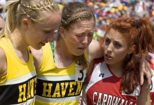 Haven senior Hailey Davis shows a mixture of disappointment and exhaustion as she is helped from the finish line by teammate Madison Caffrey and Sedgwick County's Melissa Olson after the girls 4 x 800 Class 3A State Championship, Saturday May 25, 2013, on the Wichita State University Campus. Haven placed second in the event. 